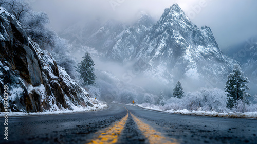 Moody winter mountain landscape, snow covered alpine peaks and pine trees, empty highway road perspective travel background