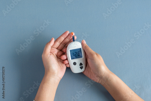 Quadro su tela Woman's hands checking diabetes and hyperglycemia with digital blood sugar meter