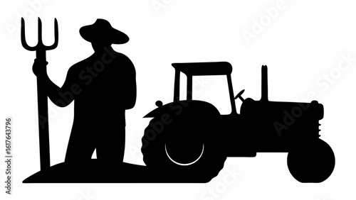 Silhouette of a farmer holding a pitchfork standing next to a tractor in a field at the farmstead
