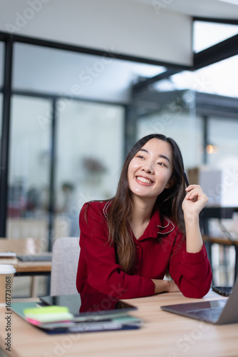 hispanic asian woman using laptop computer in office.