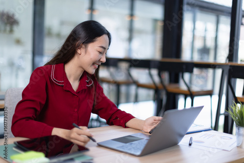 hispanic asian woman using laptop computer in office.