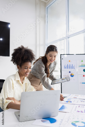 Two business woman working together for analysis data plan business strategies at desk in office, Business discussing and startup concept.