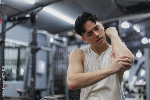 Foto Young athlete experiencing elbow pain in gym