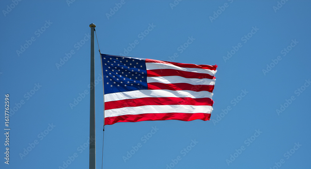 Fototapeta premium United States Flag Waving Proudly Against a Brilliant Blue Sky Backdrop