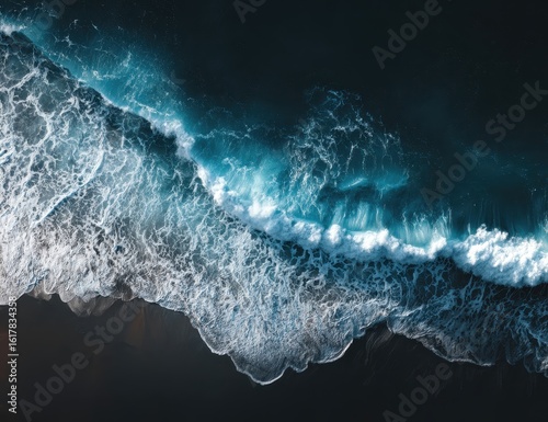 Dark sand beach meets powerful turquoise waves
