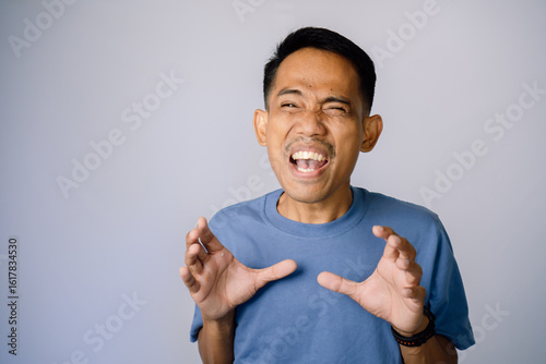 Fotografie Anxious Adult Male In Blue Shirt Against Light Gray Background