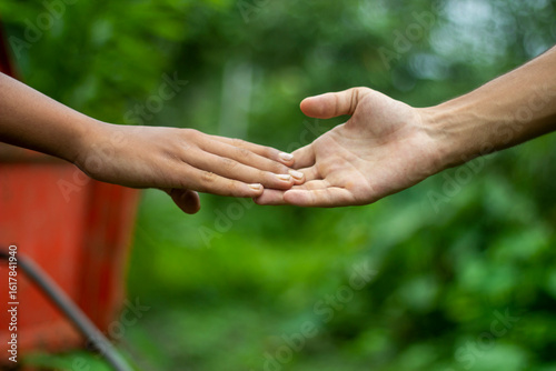 The younger brother is letting go of the older brother's hand emotionally, and the background behind them is blurred.