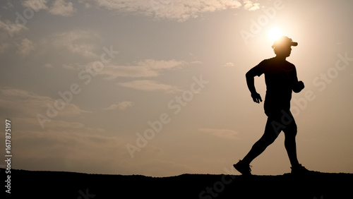 Wallpaper Mural Sunset Silhouette of a Jogger: A lone jogger, cast as a silhouette against the warm hues of a setting sun, embodies perseverance and tranquility, a testament to the daily commitment to well-being. Torontodigital.ca