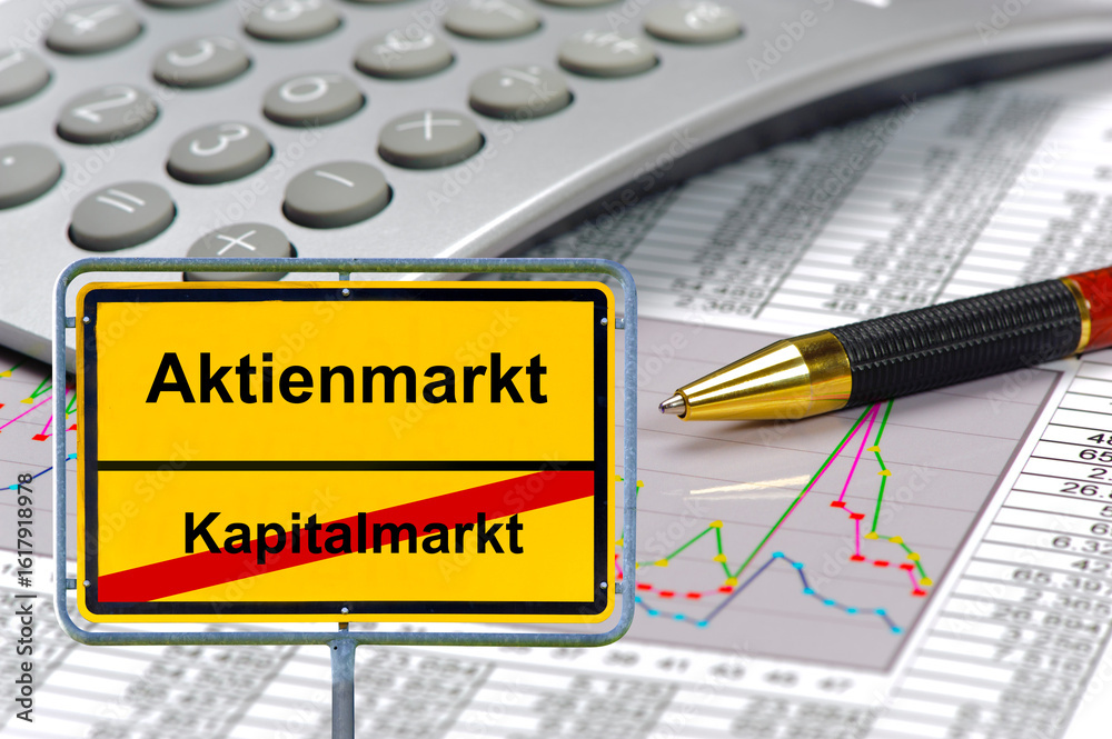 Ein Ortsschild ist beschriftet mit dem Aufdruck Aktienmarkt vs. Kapitalmarkt und steht als Symbol vor einem Chart mit Zahlentabelle - FOTOMONTAGE Ein Ortsschild ist beschriftet mit dem Aufdruck Aktienmarkt vs. Kapitalmarkt und steht als Symbol vor einem Chart mit Zahlentabelle - FOTOMONTAGE