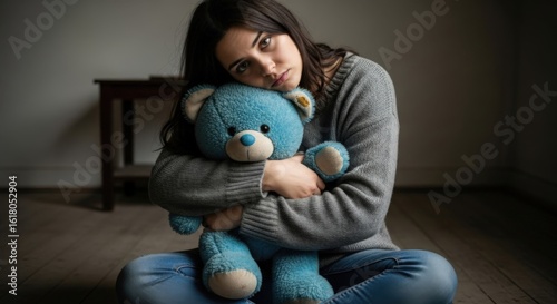 Serene Solitude: A melancholic young woman finds solace in the embrace of a comforting teddy bear, capturing a moment of introspective reflection.