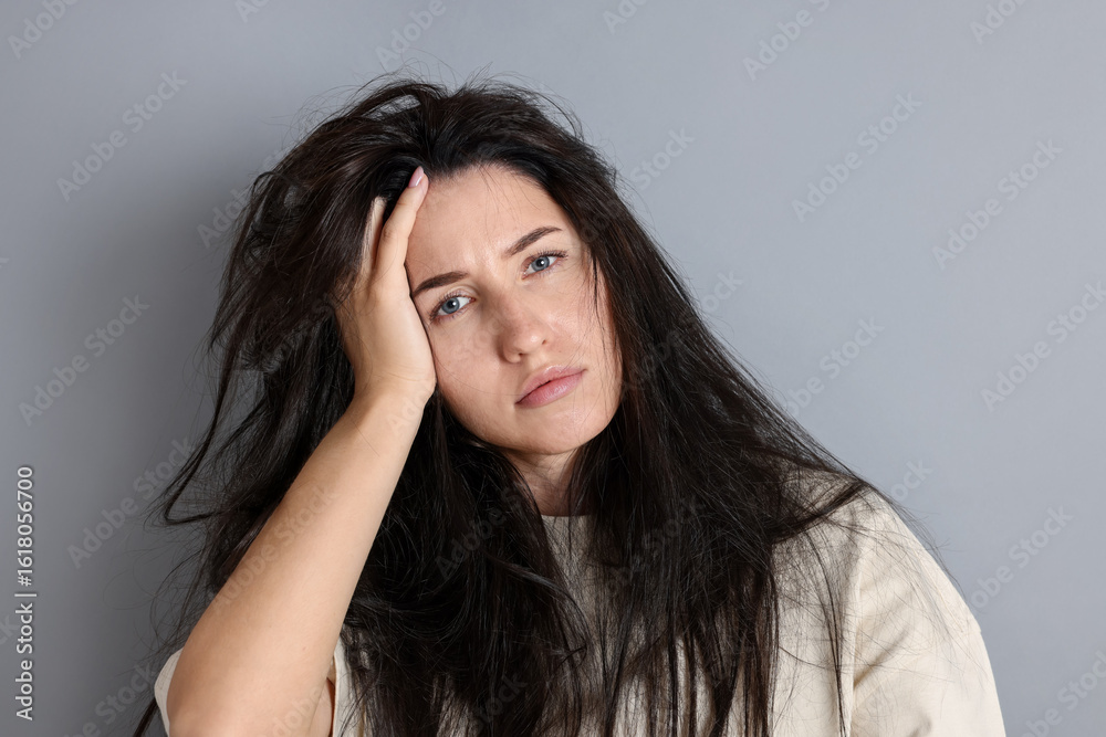 Obraz premium Woman suffering from hangover on grey background