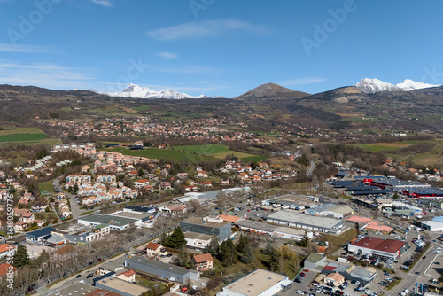 Wallpaper Mural High angle view of a residential town, industrial zone and snowcapped mountains in southeastern France under clear spring sky Torontodigital.ca