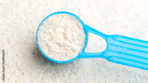 Scoop of powdered infant formula on top of baby milk powder