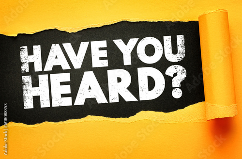Tablou pe pânză Bold white text HAVE YOU HEARD? emerges behind torn yellow paper on a black ba