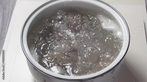cooking meatballs with boiling water in a pot