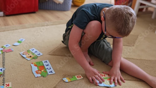 Little boy playing with word puzzles. Family, indoor activity, school preparations, exercise, education, disability. Customized curriculum.