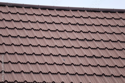 old roof tilesHouse roof with steel roofing sheet. Traditional metal shingle tiles. Gray modular tile effect roof panel. Profiled metallic corrugated pantile as concrete slate. Building's cover