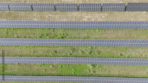 Aerial Video of Solar Farm with Parallel Solar Panels on Grass Field