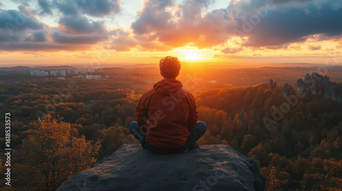 Wallpaper Mural a solo traveler sitting on a rock, gazing at a panoramic sunset view from a high viewpoint Torontodigital.ca