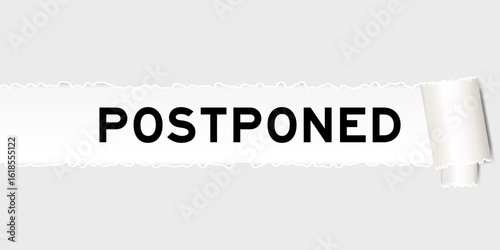Ripped gray paper background that have word postponed under torn part
