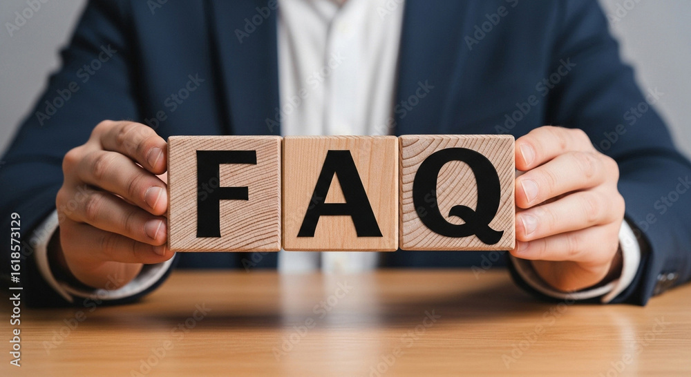 Obraz premium Businessman holds wooden blocks spelling FAQ for customer support solutions