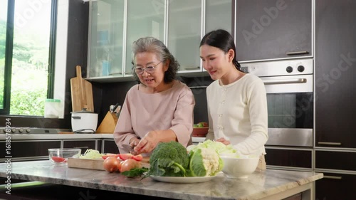 In the kitchen, a daughter and her elderly mother share a special bonding moment through cooking. Their care reflects family values, showcasing the role of a caregiver in retirement lifestyles