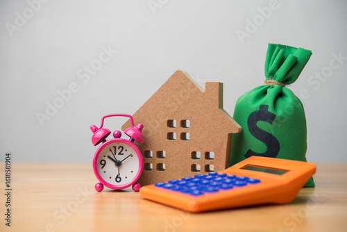 Obraz na plátně House, alarm clock, money bag and calculator on table white wall background