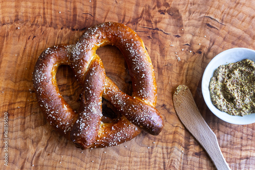 Freshly baked soft pretzels with coarse salt, served with a rustic grainy mustard dip, perfect as a traditional German snack or Oktoberfest appetizer.