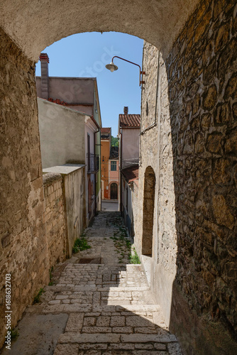 Fototapeta Naklejka Na Ścianę i Meble -  A narrow street among the old houses of Salcito, a small town in the province of Campobasso, Italy.