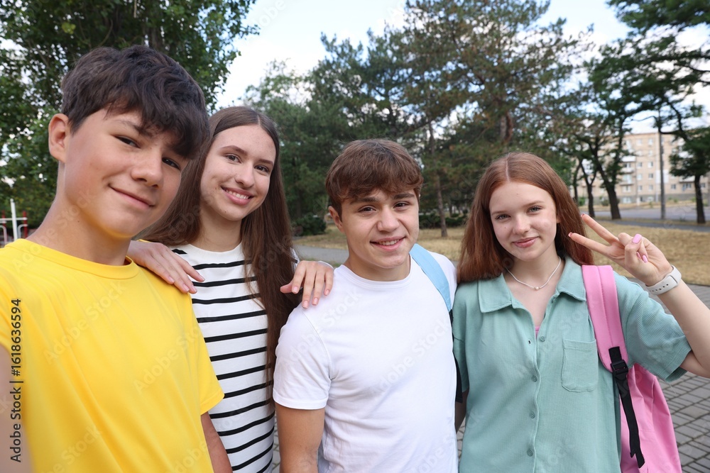 Obraz premium Group of teenagers taking selfie in park