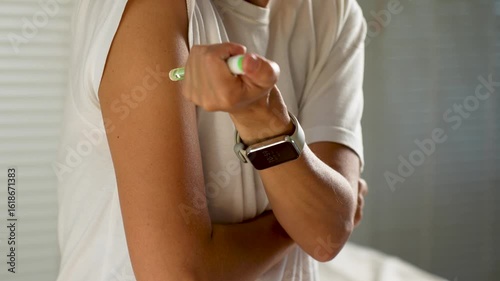 Close-up of woman hand injecting insulin pen in shoulder