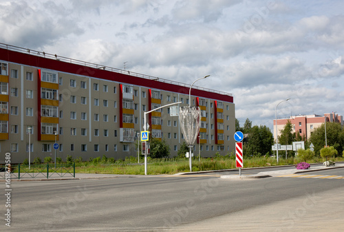 Fototapeta Naklejka Na Ścianę i Meble -  View of the building along Mira Avenue in the city of Noyabrsk in summer