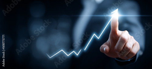 Businessman touching a glowing upward arrow graph symbolizing business growth, success, and financial progress

