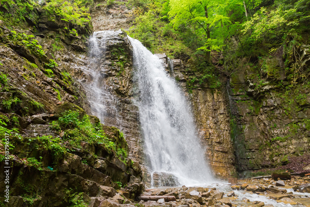 Naklejka premium Maniava waterfall falling from precipitous cliff ledge in Ukrainian Carpathians