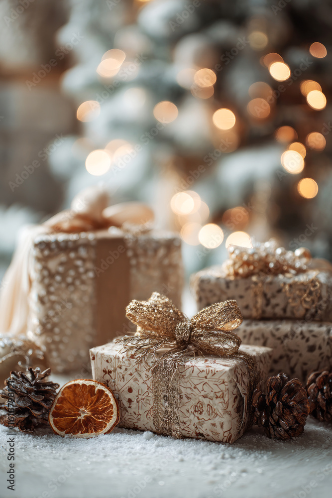 Elegant wrapped gifts with golden bows, pinecones, and dried orange slices rest on snow-dusted surface with festive lights and soft holiday bokeh. ai generative Elegant wrapped gifts with golden bows, pinecones, and dried orange slices rest on snow-dusted surface with festive lights and soft holiday bokeh. ai generative