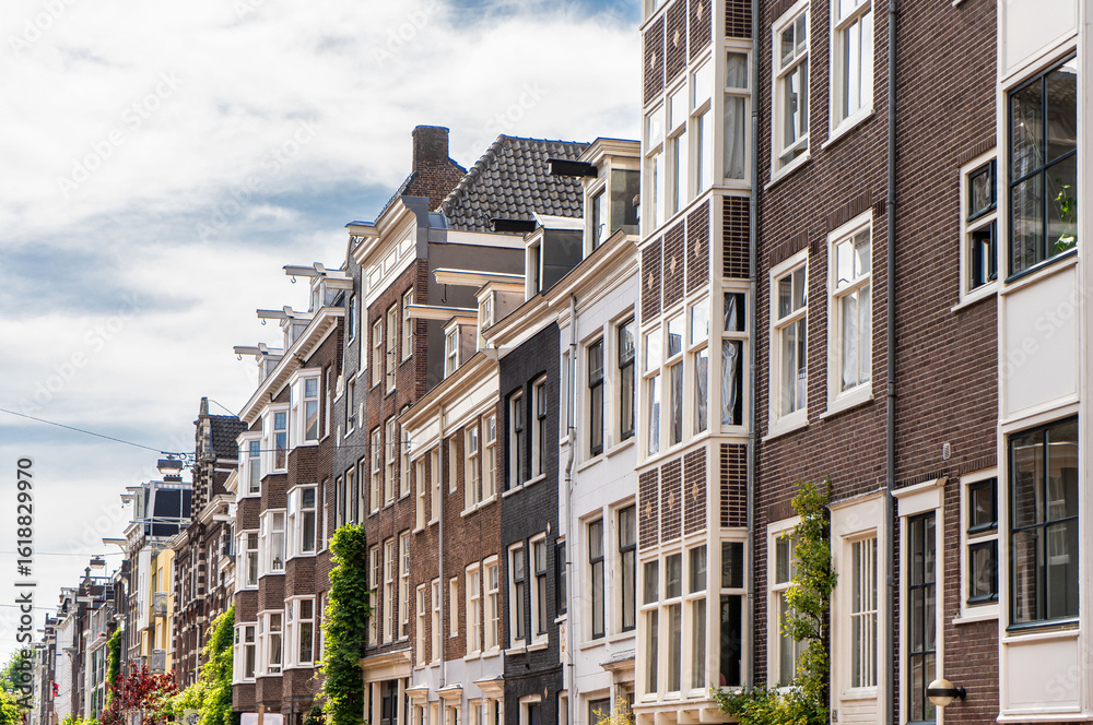Fototapeta premium Details and facades of Amsterdam characteristic brick construction of residential building in Amsterdam School style. High quality photo