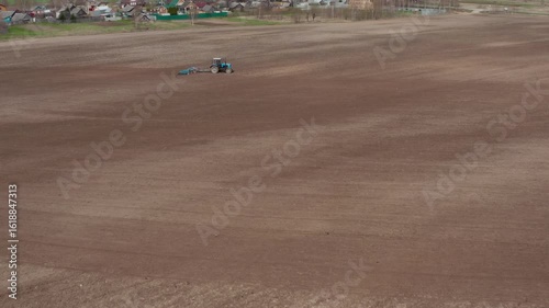 Aerial view of a tractor with a grain seeder in the field