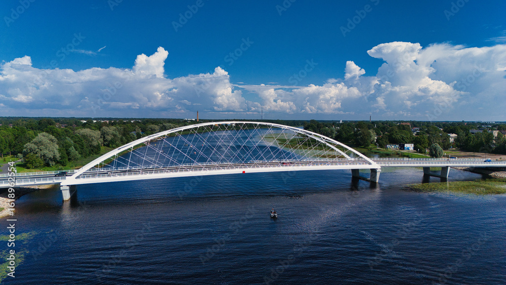 Fototapeta premium Modern White Rääma Arch Bridge Over Pärnu River - Aerial View, Estonia