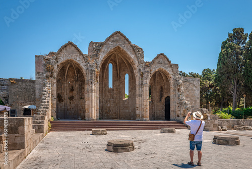 An unidentified tourist takes photo of the ruins of the Church of Panagia tou Bourgou (Our Lady of the Bourg), built in the 14th century in the island of Rhodes, Dodecanese, Greece.