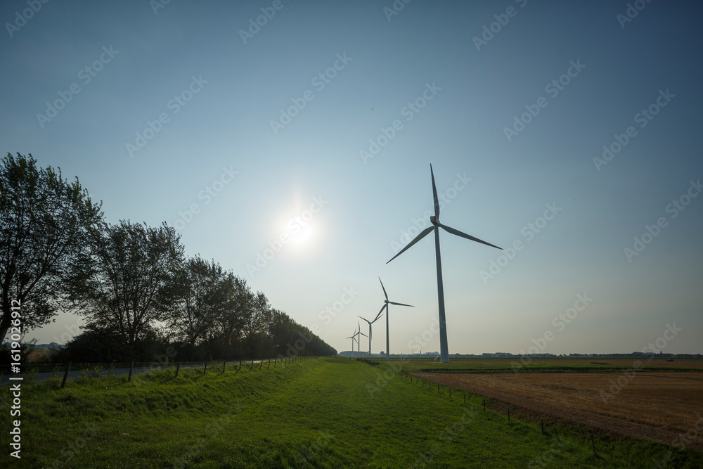 Obraz premium Wind turbines generate renewable energy in an open landscape during a clear afternoon
