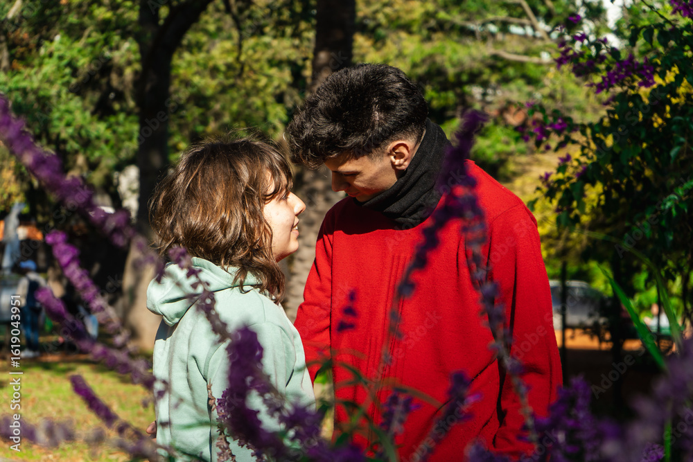 Fototapeta premium Young couple sharing a romantic moment in blooming park