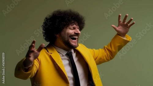 A joyous individual in a yellow suit with open arms, smiling widely, against a green background