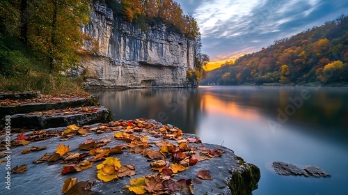 Autumn Leaves Adorn Rocky Shore Near Calm River Cliff
