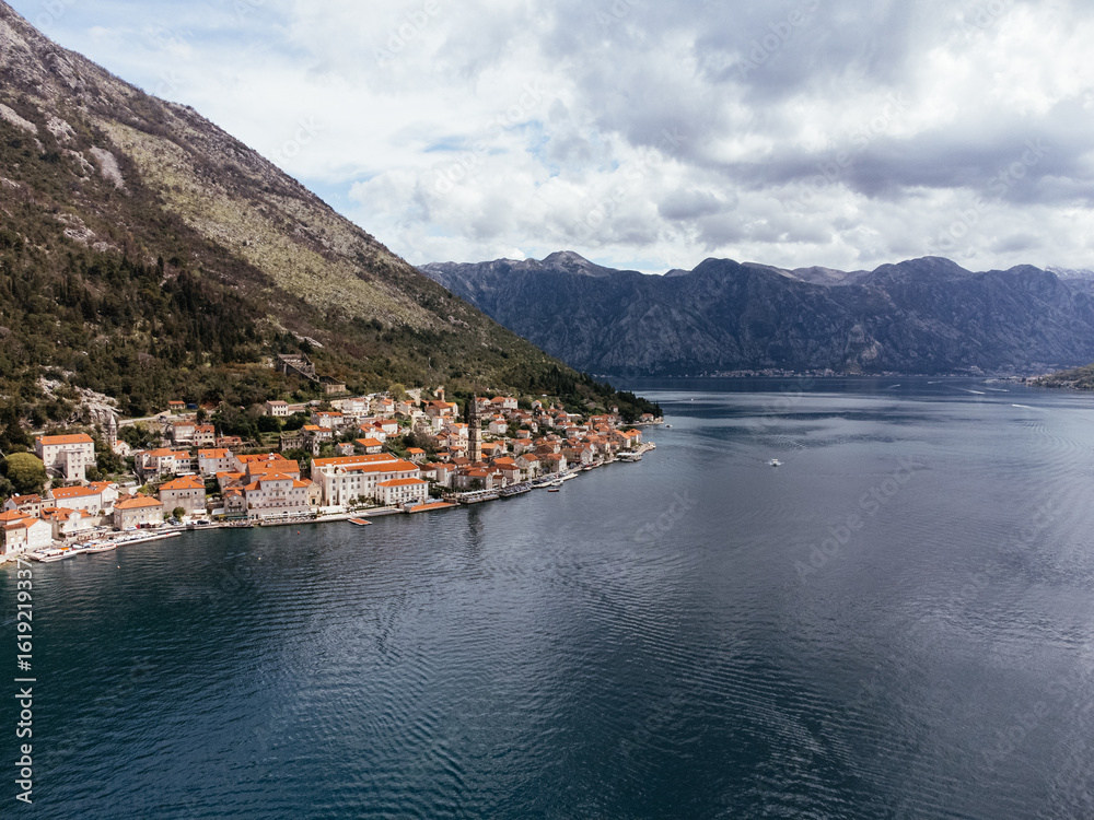 Fototapeta premium Aerial view of Saint George Island near Perast in the Bay of Kotor, Montenegro, surrounded by calm sea and mountains. g.