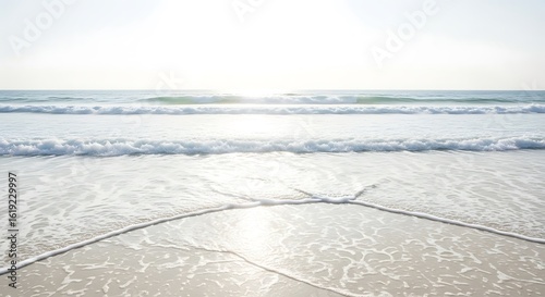 Photo of gentle waves washing onto a sandy beach on a bright sunny day