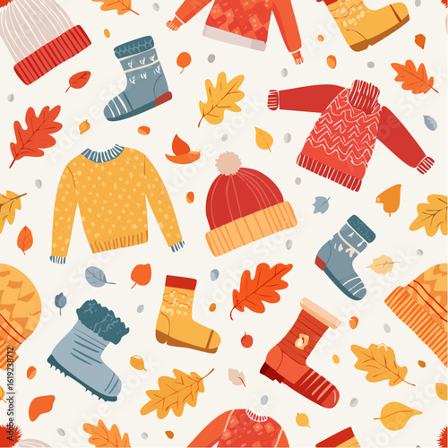 A cozy and colorful autumn pattern featuring knitted hats, warm sweaters, and patterned socks scattered amongst fallen leaves in vibrant fall colors.