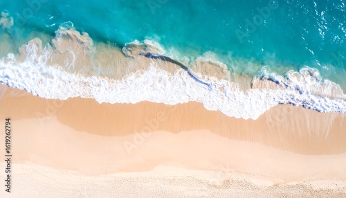 Fototapeta Naklejka Na Ścianę i Meble -  Aerial view of ocean waves gently lapping a pristine sandy beach