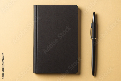 Minimalist black notebook with pen on a solid color background