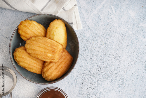 Cuadro en lienzo Bowl with delicious madeleines on white grunge background