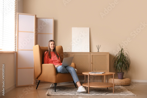 Young woman using laptop wh...
